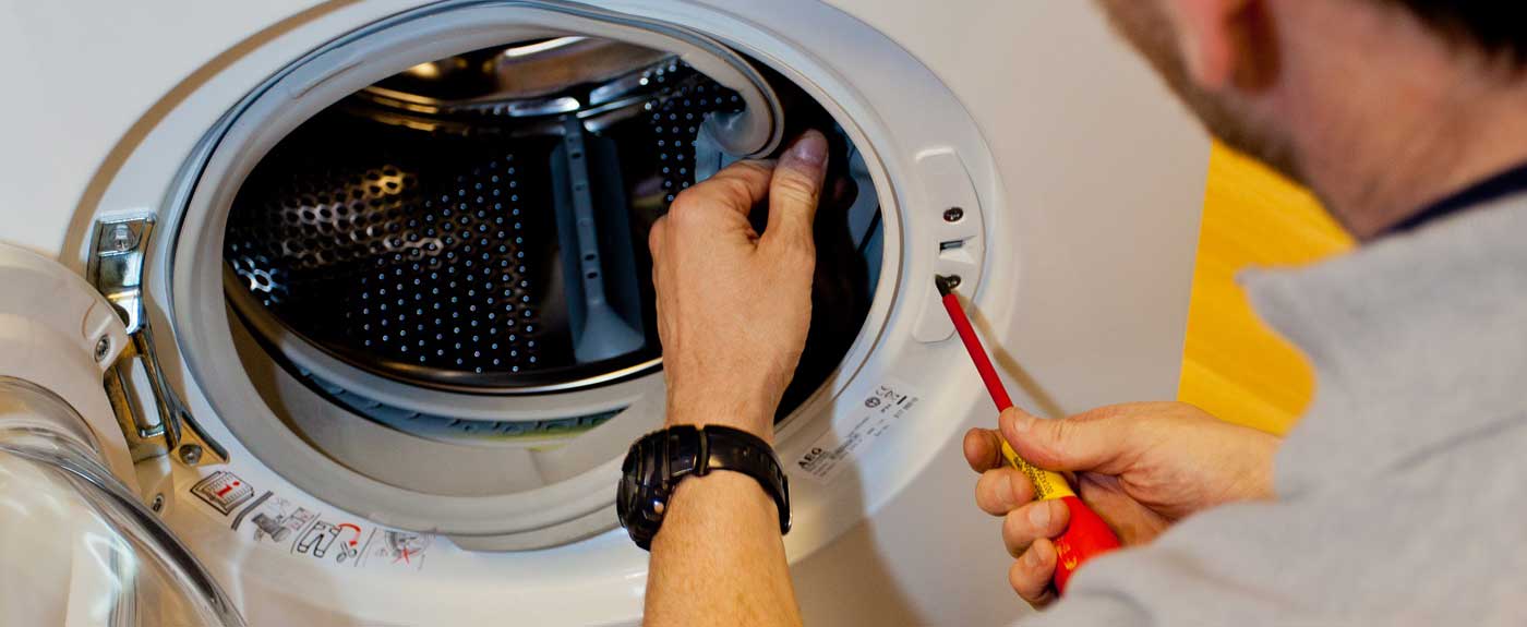 Wash Care Services technician repairing a front-load washing machine in Dwarka, Delhi